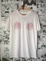 Remera blanca de algodón con dos rosas rojas bordadas en el frente.