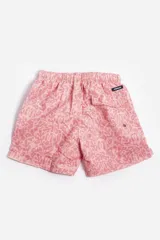 Short de baño celeste con estampado de hojas pequeñas en tonos verdes y blancos. Cuenta con cintura elástica con cordón ajustable, bolsillos laterales y un parche circular con logo en la parte inferior.