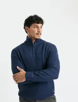 Sweater de punto inglés color verde, con cuello alto y cierre frontal parcial metálico. Diseño de manga larga con puños y ruedo acanalados.