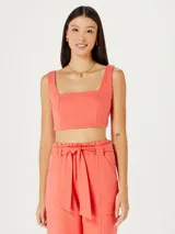 Top corto de escote cuadrado y tirantes anchos, con diseño entallado al cuerpo y costuras verticales decorativas.