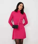 Vestido corto color fucsia, de punto, con cuello alto, mangas largas y falda acampanada.