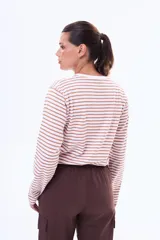 Remera de manga larga con diseño de rayas horizontales en color rojo y blanco, confeccionada en algodón, con cuello redondo y corte clásico.