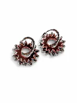 Aros de argolla plateada con dijes colgantes de acrílico espejado en tonos rosado y plateado, con diseño en forma de sol o engranaje.