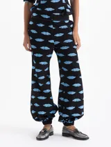Pantalón tipo babucha negro con estampado de labios azules, confeccionado en jacquard. Cuenta con cierre, doble gancho pantalonero y botón interno, puño elástico en el ruedo, bolsillos laterales y bolsillos ojal traseros.