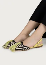 Ballerinas planas destalonadas de inspiración artesanal, con exterior en rafia trenzada con patrón en zigzag blanco y negro, y talón en napa color amarillo lima. Cuentan con una correa ajustable en el talón con hebilla dorada y una gran borla decorativa de flecos en el empeine.
