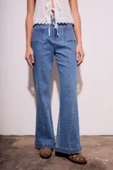 Pantalón de jean azul de corte flare y tiro medio.