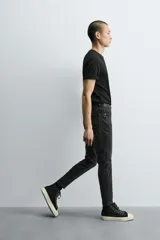 Jeans de hombre, corte skinny y largo cropped, color negro lavado. Presenta cinco bolsillos y cierre frontal con cremallera y botón.