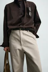 Pantalón relaxed fit para hombre, confeccionado en tejido con mezcla de algodón y lino, en color beige. Presenta bolsillos laterales, bolsillos traseros de plastrón y cierre frontal con cremallera y botón.