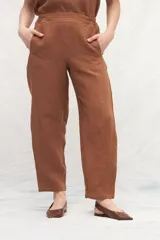 Pantalón de lino color marrón, de corte recto y tiro alto, con cintura elástica y bolsillos laterales.