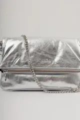 Cartera tipo bandolera de cuero metalizado plateado, con solapa frontal y logo de la marca grabado. Incluye una correa combinada de cadena metálica y cuero, desmontable y regulable.