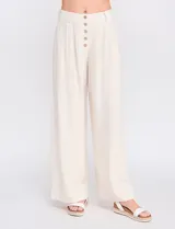Pantalón palazzo color blanco, confeccionado en mezcla de lino y viscosa, de tiro alto con cierre frontal de botones, pinzas en la cintura y piernas anchas.