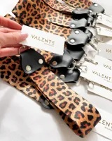 Llavero con correa de tela con estampado animal print y detalles en cuero sintético negro.