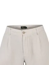Pantalón de lino color beige, de corte recto y holgado, con bolsillos laterales y cierre de botón y cremallera.