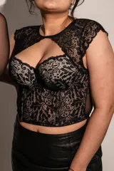 Corset negro con copas y aro, ballenas en la parte delantera, confeccionado en puntilla elastizada y microtul. Detalle de broche en el escote.