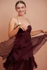 Vestido corto color vino de seda con escote corazón, breteles finos y falda con volados.