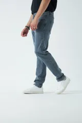 Pantalón de jean azul de corte slim, tiro medio y con presillas para cinturón.