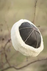Gorro negro de cuero con borde de corderito blanco.