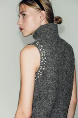 Top sin mangas confeccionado en mezcla de lana y alpaca, con cuello subido y detalle de abalorios joya aplicados en los hombros.