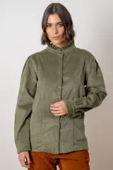 Camisa de pana color verde oliva, con cuello alto con volados, cierre frontal de botones y mangas largas con puños.