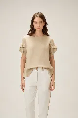 Blusa de lino color rosado, de corte recto y holgado, con cuello redondo y mangas cortas adornadas con volados.