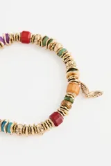 Pulsera elástica de cuentas multicolor con dije de mariposa dorada.