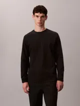 Remera de manga larga Calvin Klein confeccionada en algodón con tejido interlock. Presenta cuello redondo, corte regular y un sutil logo de la marca bordado en el pecho.