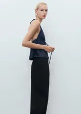 Pantalón sastrero negro de tiro bajo, con pinzas en la parte delantera, bolsillos de ribete en la parte posterior y diseño recto de largo completo.