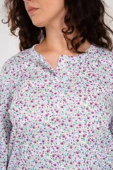 Pijama de algodón estampado con flores, compuesto por un buzo de manga larga con botones y un pantalón liso de tiro alto color lila.