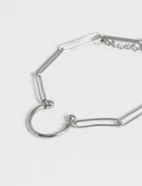 Pulsera plateada de eslabones con dije de medio círculo.