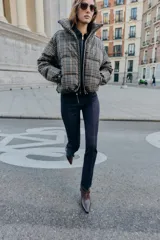 Anorak acolchado de cuello subido y manga larga con puños elásticos ajustables. Presenta un diseño de cuadros, cierre frontal con cremallera, bolsillos laterales con cierre y bajo ajustable con cordones elásticos.