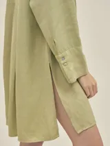 Camisa larga color crema confeccionada en lino-tencel con botones de conchas naturales y bolsillos laterales.