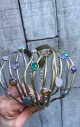 Gargantilla artesanal con cuatro hilos de bronce y alpaca, adornada con piedras de diferentes colores y formas.