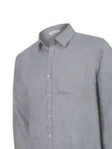 Camisa de lino de manga larga color gris, con cuello camisero, cierre frontal de botones y un bolsillo ojal en el pecho.