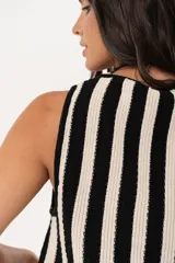 Chaleco tejido a rayas verticales en color negro y crudo, con escote en V y cierre frontal con ganchitos.