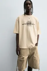 Bermuda de corte relajado en denim de algodón color beige, estilo cargo, con cinco bolsillos y bolsillos plastrón con solapa en las perneras.