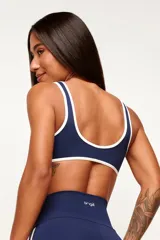 Conjunto deportivo de top y short color azul marino con detalles de ribetes en color blanco. El top es de corte ajustado con escote redondo y tirantes medios, mientras que el short es de talle alto y cuenta con líneas en contraste a los costados y en las piernas.