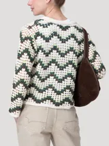 Sweater tejido a crochet de manga larga, con cuello polo y escote en V, con diseño geométrico en tonos beige, verde y marrón.