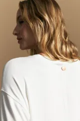 Remera de calce relajado con silueta fluida, confeccionada en tejido de viscosa con elastano. Presenta cuello redondo, mangas cortas y un diseño minimalista de caída suave.