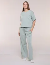 Conjunto de buzo de manga corta con hombros caídos y escote redondo, acompañado de un pantalón tipo wide leg de tiro alto con cintura elástica y cordón de ajuste, en color verde.
