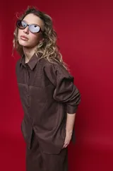 Camisa de manga larga con diseño de rayas verticales y horizontales en color marrón. Presenta un corte oversize con hombros caídos, cuello clásico y cierre frontal con botones.