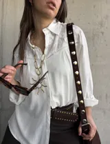 Camisa blanca de manga larga con detalles bordados en el canesú y cuello clásico.