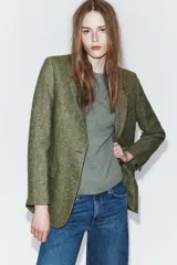 Blazer de Zara confeccionado en hilatura con lana, con diseño de espiga en tonos marrones. Presenta cuello solapa, manga larga con botones, bolsillo de vivo en el pecho y bolsillos delanteros con solapa. Cierre frontal con botones y forro interior negro.