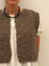 Collar corto de piedras volcánicas negras en la base del cuello, con pequeños detalles en tonos tostados y dorados.