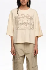 Remera corta de corte oversize confeccionada en mezcla de algodón color beige. Presenta escote redondo, mangas cortas amplias y un maxibordado en el delantero.