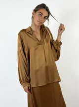 Blusa color bordó de mangas largas con puños abotonados, cuello camisero y escote en V.