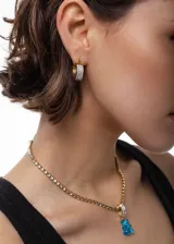 Collar dorado con cadena de eslabones y dije de oso de gomita color celeste.