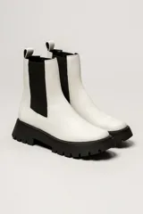 Bota Chelsea color verde militar de cuero, con elásticos laterales negros, tirador trasero y suela track negra.