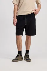 Bermuda de caída suelta con cintura elastizada y cordón regulable, confeccionada en tejido texturado negro.