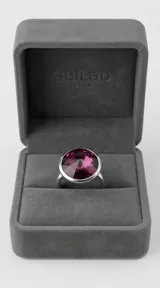 Anillo de plata con cristal redondo facetado en color amatista, engarzado en un diseño minimalista.