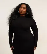 Vestido corto evasé de punto negro con cuello alto y mangas largas.